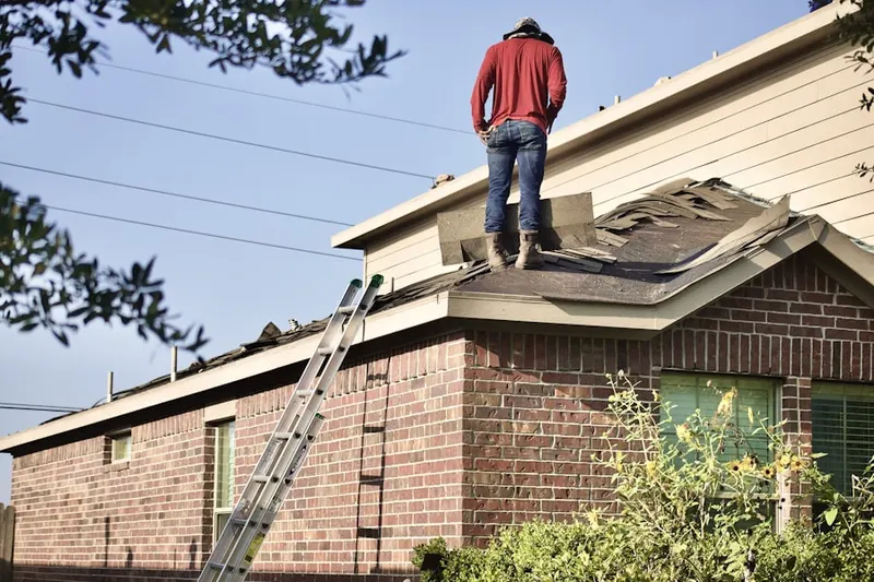Professional roofer working on a residential roof in Guttenberg